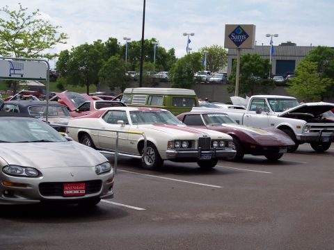 1972 Ford Ranchero - A row of classic cars are parked in a lot with a Sam's Club in the background.
