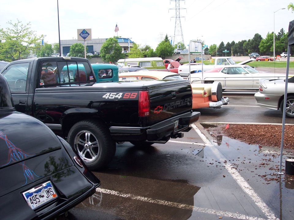 Black Chevrolet pickup truck with 454 SS badging, parked on a wet lot