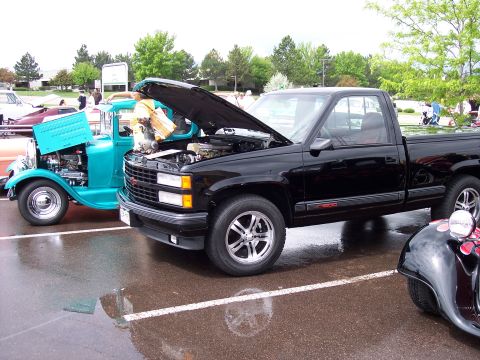 1972 Ford Ranchero - A black pickup truck and a teal hot rod are parked side-by-side with their hoods open.