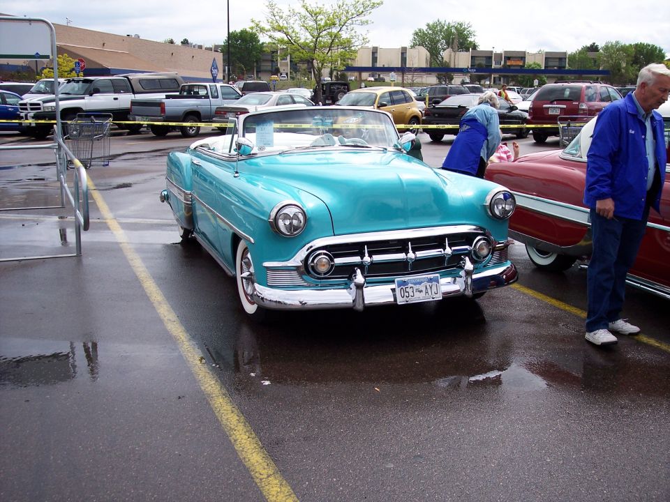 Turquoise convertible with whitewall tires and chrome grille. License plate reads 053-AYJ