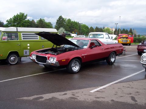 1972 Ford Ranchero - A red 1972 Ford Ranchero is displayed with its hood open, parked in a lot with other vehicles.