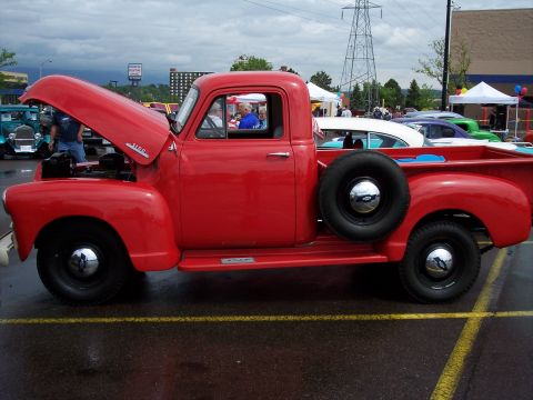 1972 Ford Ranchero - A classic red pickup truck is displayed with its hood up, parked next to other vintage vehicles.