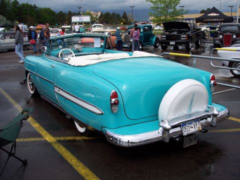 1972 Ford Ranchero - A classic turquoise convertible with a continental kit is displayed at an outdoor event with other vehicles.