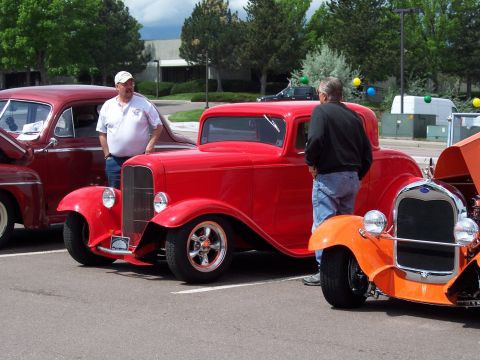 1972 Ford Ranchero - A bright red 1932 Ford coupe is parked next to other classic cars at an outdoor event.