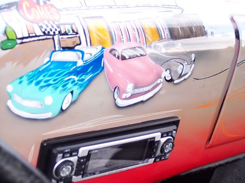 1972 Ford Ranchero - A car door displays a painted mural of vintage vehicles and a diner scene, complete with an aftermarket stereo.