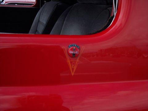 1972 Ford Ranchero - A Coca-Cola emblem is visible on the red exterior of a vehicle, with a glimpse of the black interior.