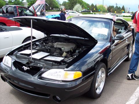 1972 Ford Ranchero - A black convertible, possibly a Ford Mustang, is displayed with its hood open, revealing the engine compartment.