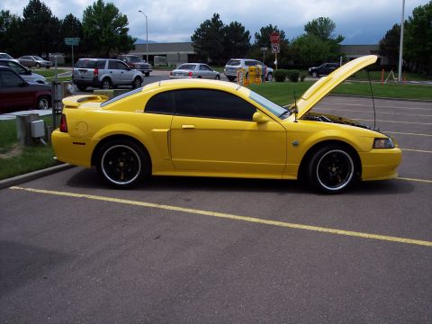 1972 Ford Ranchero - A yellow coupe is parked in a lot with its hood open, revealing the engine compartment.