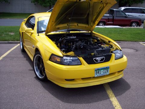 1972 Ford Ranchero - Front view of a yellow Ford Mustang with its hood open, revealing the engine compartment.