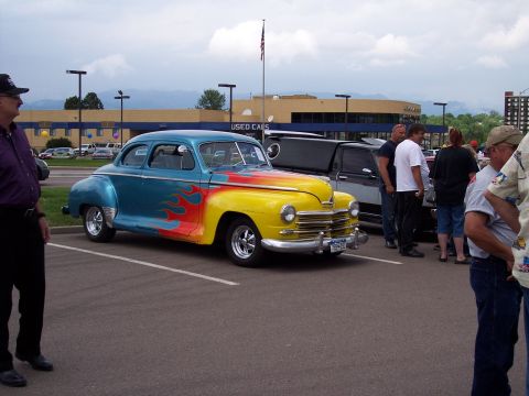 1972 Ford Ranchero - A vintage coupe with custom paint and flame decals is displayed at an outdoor event.