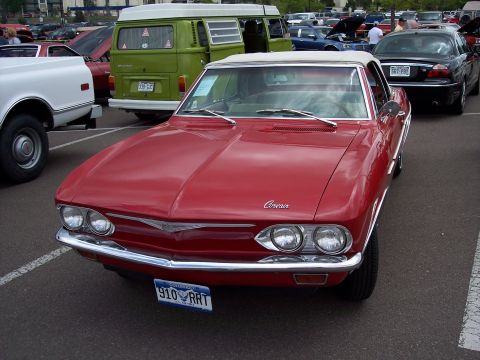 1972 Ford Ranchero - Red convertible parked in a lot with other vehicles, including a green van and a white pickup.