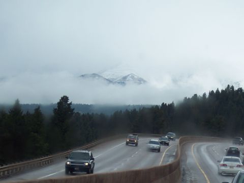 1972 Ford Ranchero - Vehicles travel on a highway under a cloudy sky with snow-capped mountains visible.