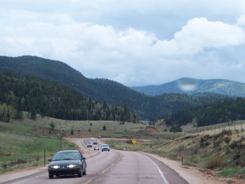 1972 Ford Ranchero - Cars travel on a highway surrounded by forested mountains and rolling hills.