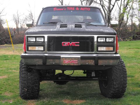 1991 GMC Jimmy - This GMC pickup truck, likely from the late 1980s, has a prominent grille and is modified with off-road tires.