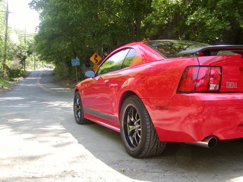 2004 Ford Mustang - A red 2004 Ford Mustang Mach 1 is parked on the side of a rural road.