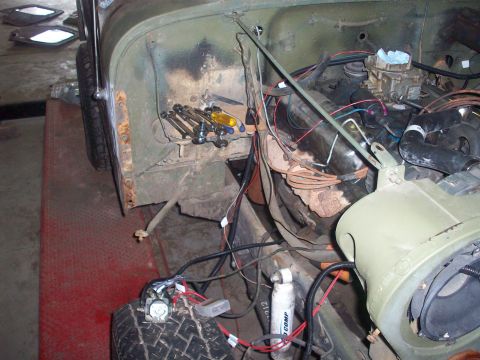 1978 Jeep CJ5 - Close-up view of the engine bay and front fender area of a green vehicle, showing engine components and wiring.