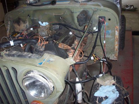 1978 Jeep CJ5 - The engine bay of a Jeep CJ is shown, with various components and wiring laid out for inspection or repair.
