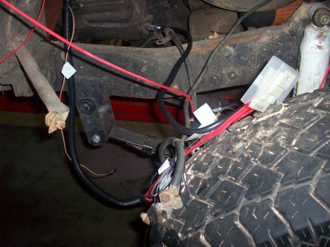 1978 Jeep CJ5 - Detail of a vehicle's undercarriage, showing electrical wiring and a tire.