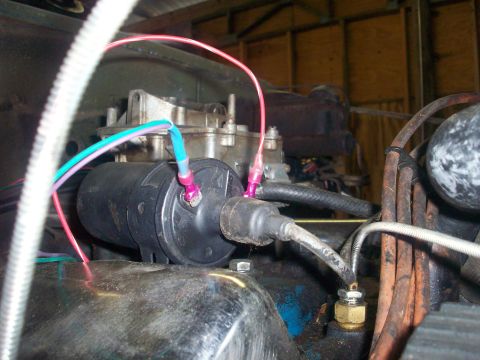 1978 Jeep CJ5 - Close-up of an engine's ignition coil and wiring, with a carburetor in the background.