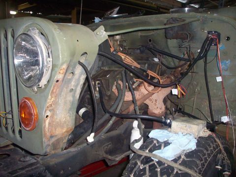 1978 Jeep CJ5 - The front portion of a Jeep shows its engine bay with visible wiring and engine parts, suggesting ongoing work.