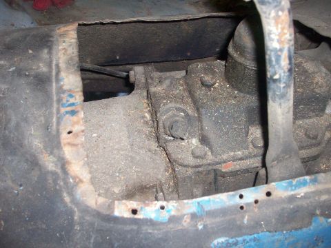 1978 Jeep CJ5 - Close-up view of the transmission tunnel interior, revealing rusted metal and mechanical components within a Jeep CJ-5.