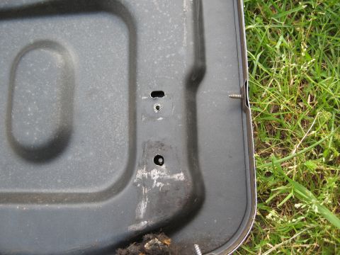 1968 Shelby GT500 - A close-up view of a metal panel with visible screws and surrounding grass.