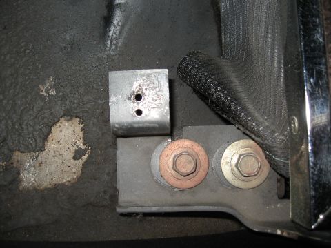 1968 Shelby GT500 - Detail of a seatbelt anchor bracket and mounting hardware inside a vehicle.