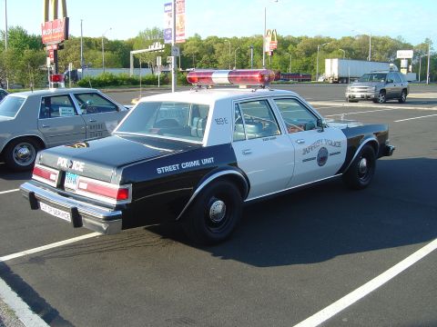 2001 Ford Crown Victoria - A black and white police car is parked in a lot, with another police car visible behind it.
