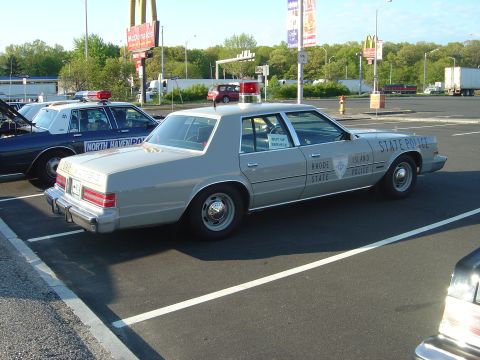 2001 Ford Crown Victoria - A gray Rhode Island State Police car is parked in a lot next to another police vehicle.