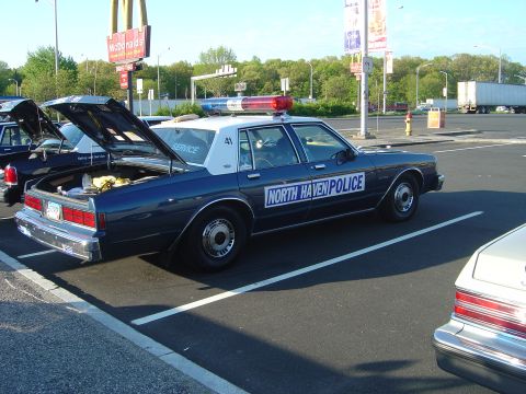 2001 Ford Crown Victoria - A North Haven Police car is parked with its trunk open, showing equipment inside.