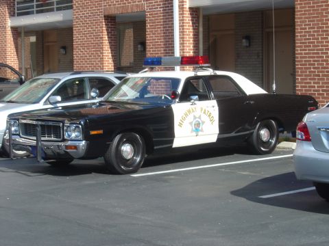 2001 Ford Crown Victoria - This vintage police car is black and white with a light bar on top.