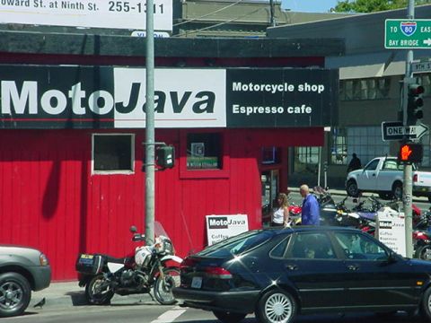 1979 Ford Bronco - Red MotoJava motorcycle shop and espresso cafe on a city corner with parked bikes, cars, and a Bay Bridge I-80 sign.