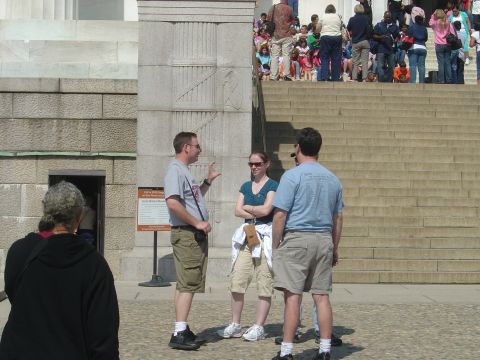 2001 Ford Crown Victoria - A group of people are gathered on the steps of a large stone building, with more people visible in the distance.