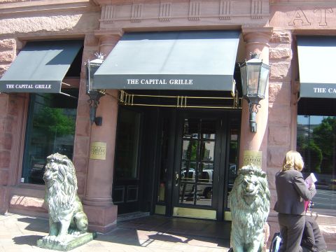 2001 Ford Crown Victoria - The main entrance of The Capital Grille restaurant is flanked by two lion statues and features prominent awnings with the restaurant's name.
