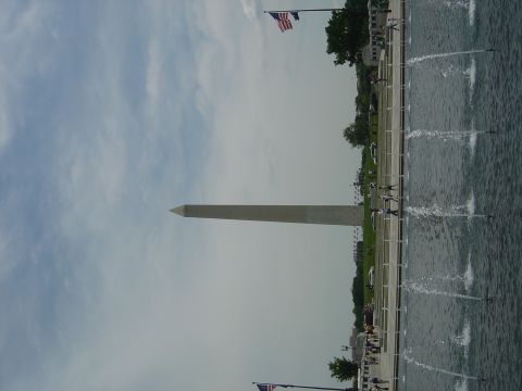 2001 Ford Crown Victoria - The Washington Monument stands tall against a cloudy sky, with fountains spraying water nearby.
