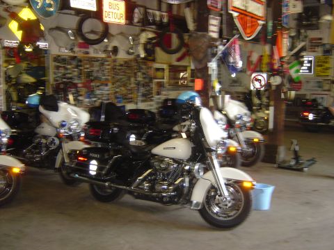 2001 Ford Crown Victoria - Several police motorcycles are parked indoors, with one in the foreground showing 'POLICE' on its side.