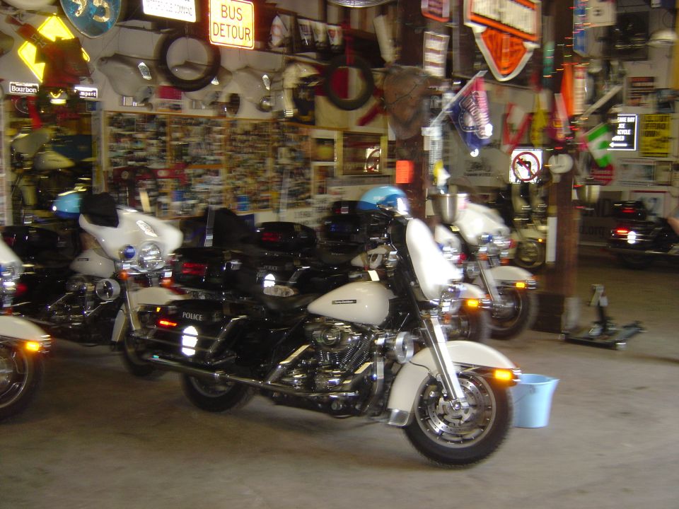 Police motorcycles parked in a garage, one white and black with 'POLICE' visible