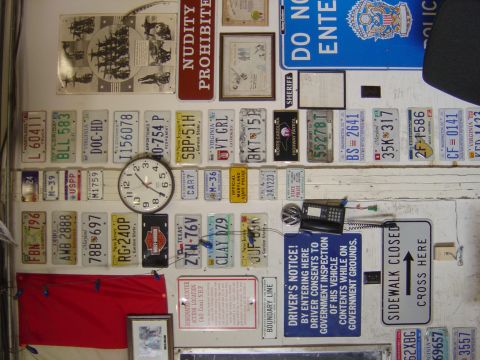 2001 Ford Crown Victoria - A collection of license plates and various signs are displayed on a wall.