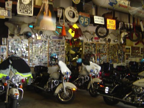 2001 Ford Crown Victoria - A collection of police motorcycles are parked in a garage filled with various signs and photographs on the walls.