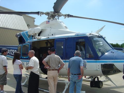 2001 Ford Crown Victoria - A blue and white helicopter, identified as N412PP and belonging to the Park Police, is viewed from the side with several people standing ne…