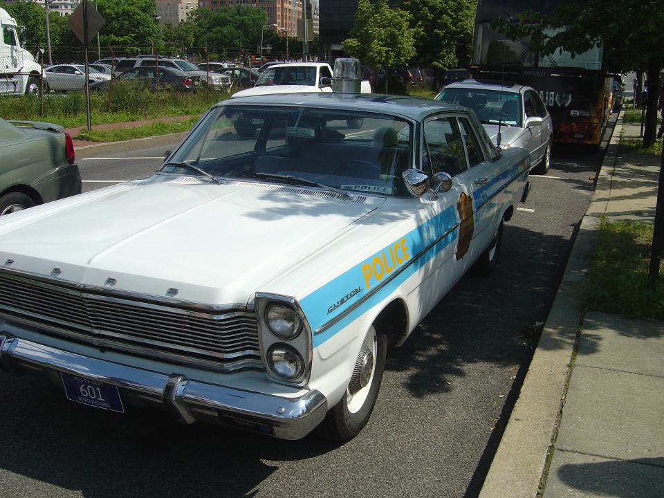 1966 Ford Custom police car, front quarter view, white with blue stripe and 'POLICE' text