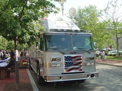 2001 Ford Crown Victoria - A fire truck with an American flag decal on its grille is parked on a street.
