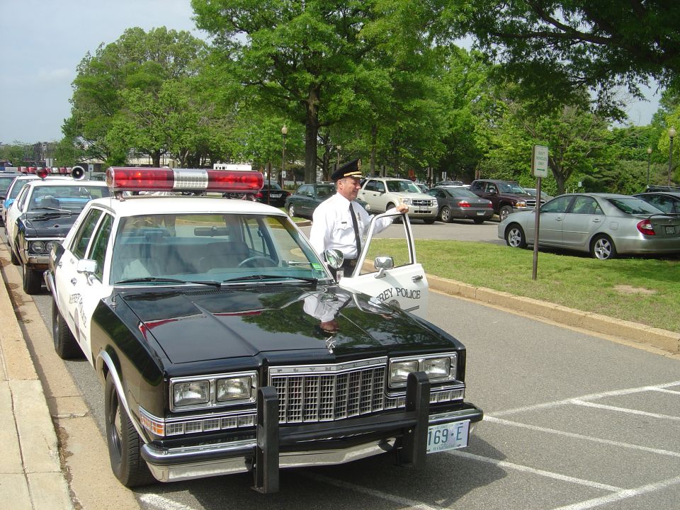 Black and white police car with light bar and push bumper