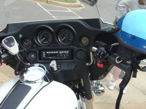 2001 Ford Crown Victoria - The interior view of a motorcycle shows the dashboard with gauges, radio, and a Motorola microphone, along with a blue helmet resting on th…
