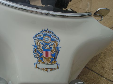 2001 Ford Crown Victoria - Close-up of a white motorcycle's fairing the United States Park Police emblem.