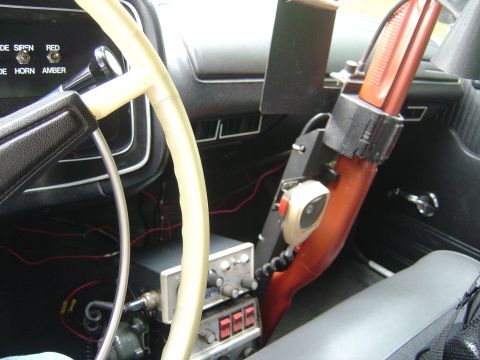2001 Ford Crown Victoria - The interior of a vehicle shows a steering wheel, radio equipment, and a microphone, suggesting it may be a police or emergency vehicle.