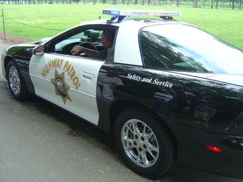 2001 Ford Crown Victoria - This police car, likely a 1993 Chevrolet Camaro, is marked "HIGHWAY PATROL" and "Safety and Service".