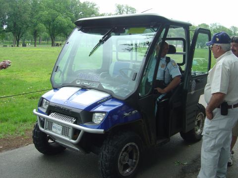 2001 Ford Crown Victoria - A police officer sits in a Polaris XP UTV while two civilians stand nearby.