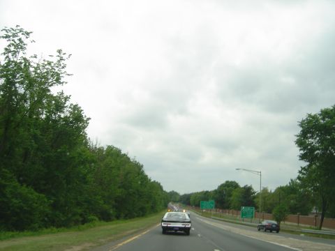 2001 Ford Crown Victoria - A black and white sedan is seen driving on a highway with other vehicles.
