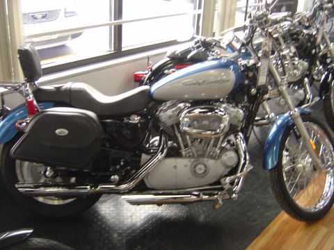 2001 Ford Crown Victoria - A blue and silver motorcycle is parked indoors, with another motorcycle visible to its right.